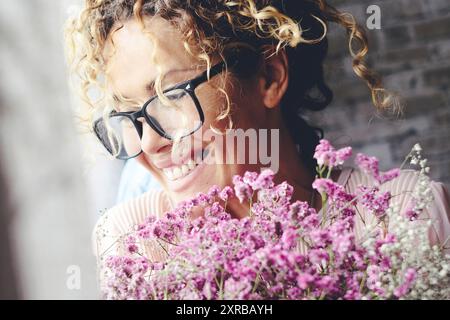 Une jeune femme excitée ravie à la maison avec un grand bouquet de fleurs. Anniversaire et anniversaire célébration du bonheur des femmes. Amour et relation. Nouveau petit ami de rencontre recevant cadeau à la maison Banque D'Images