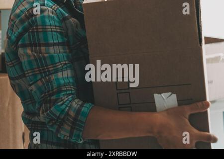Une femme heureuse souriante déplaçant la boîte en carton de l'ancienne à la nouvelle maison. Relocation appartement Banking concept hypothécaire, activités de loisirs intérieures femmes. Indépendance et vie seule femme de style de vie Banque D'Images