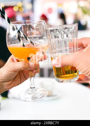 Des amis déguerent des cocktails de fantaisie - les jeunes s'amusent ensemble à boire de la bière et du vin à l'happy hour - concept de fête de style social Life Banque D'Images