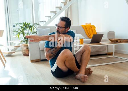 sport, fitness et concept de mode de vie sain - homme faisant des exercices abdominaux à la maison. Un mâle mature seul faisant le sport d'entraînement d'appartement intérieur pour les soins de santé du corps et un mode de vie sain le matin Banque D'Images