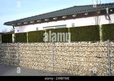 Allemagne, Bavière, haute-Bavière, Neuötting, maison individuelle, haute clôture de jardin, mur de gabion, thujas Banque D'Images