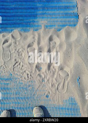 Deux chaussures dans la coupe sur tapis bleu avec du sable fin à la lumière du soleil, station de vacances et station balnéaire Baltique Prerow, Fischland Darß, Mecklembourg-Poméranie occidentale, Allemagne Banque D'Images