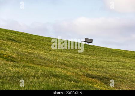 Un banc sur la digue de Friedrichskoog-Spitze, mer du Nord, Friedrichskoog, Schleswig-Holstein, Allemagne Banque D'Images