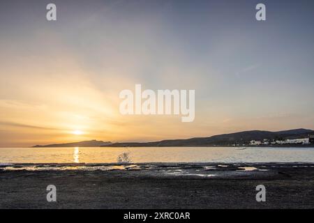 Coucher de soleil avec vue sur la mer sur une côte rocheuse aux couleurs chaudes, paysage sur la plage de Tarajalejo à Fuerteventura, îles Canaries, Espagne. Banque D'Images