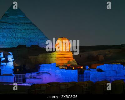 Vue panoramique de l'illumination du grand sphinx de Gizeh à côté de la pyramide de Kefren pendant le spectacle de lumière nocturne au Caire Egypte Banque D'Images