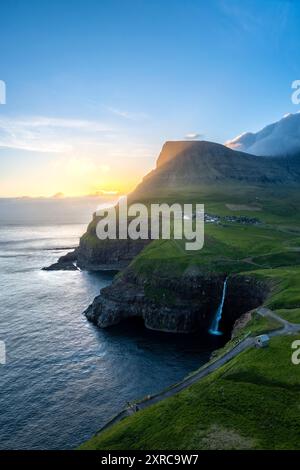 Vue aérienne de la cascade Mulafossur avec le petit village de Gasadalur, île de Vagar, îles Féroé, Danemark, Europe, Banque D'Images