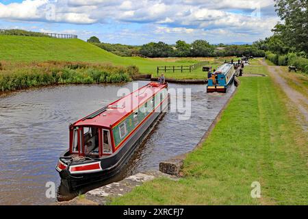 Les gens sur les bateaux étroits du canal, se croisant aux écluses de Hurleston sur le canal de Llangollen à Hurleston Cheshire Angleterre Royaume-Uni Banque D'Images