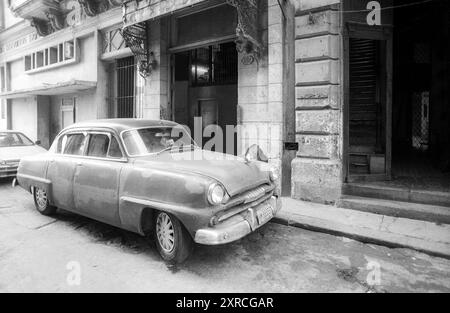 2001 photographie d'archive en noir et blanc d'une vieille voiture américaine devant une propriété à la Havane, Cuba. Banque D'Images