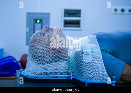 Patient sous masque pour un traitement par radiothérapie du cerveau entier ou par radiothérapie du cerveau total pour cibler les cellules tumorales Banque D'Images