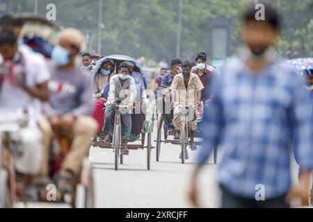 Les tireurs de pousse-pousse transportent des passagers sur la route de l'aéroport, dans la matinée à Dhaka, le lundi 11 juillet. Les pousse-pousse sont normalement interdits d'utilisation des routes, mais sont autorisés pendant le verrouillage actuel. Le Bangladesh traverse une vague de COVID-19, avec un record de 13768 cas le lundi 12 juillet. Le 14 juillet, les restrictions au confinement seront assouplies pendant neuf jours pour les célébrations d'Eid-ul-Azha. Les tireurs de pousse-pousse comptent parmi les travailleurs les moins bien payés au Bangladesh et ont ressenti les restrictions très durement. Au cours des efforts précédents sur le verrouillage, les tireurs de pousse-pousse où Banque D'Images