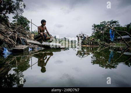 Mohammad Khokon s'assoit à côté de ce qui était la maison de sa famille. Une crue éclair lavé dans la rivière Jamuna dans Sirajganj, Bangladesh en 2007. La cause du réchauffement de la pluie de mousson et les inondations à commencer plus tôt. Aussi accellerate le réchauffement de la fonte de la glace et de la neige dans l'Himalaya, qui alimente les rivières déjà saturé qui rendent le delta du Gange. Le résultat est catastrophique pour les personnes qui vivent dans la région du delta à forte densité de population. Alors que l'Himalaya et les inondations font des ravages depuis le nord, l'élévation du niveau de la cause d'eau salée dans les basses zones agricoles le long e Banque D'Images