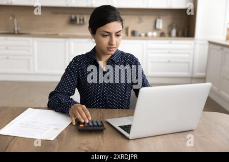 Femme indienne sérieuse gérer les finances, payer les factures via les services bancaires en ligne Banque D'Images