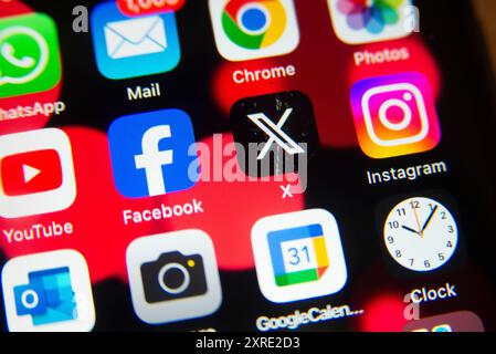 Gros plan de l'écran d'accueil d'un smartphone affichant des applications de médias sociaux populaires, notamment Facebook, Instagram, WhatsApp, YouTube et l'application X. Banque D'Images