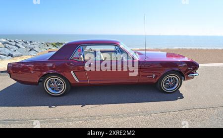 Classic Purple Ford Mustang garée sur la plage de bord de mer et la mer en arrière-plan. Banque D'Images