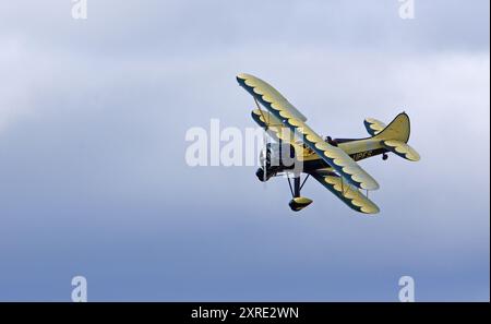 Vintage Waco UPF-7 biplan en vol contre les nuages. Banque D'Images