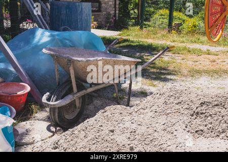Une brouette vide sur un chantier de démolition de maison de bâtiment. Copier l'espace Banque D'Images
