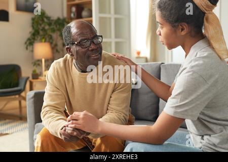 Homme âgé interagissant avec une fille afro-américaine offrant le confort Banque D'Images