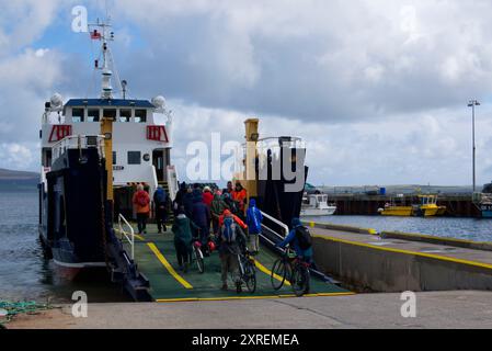 Marcheurs et cyclistes sur Rousay Ferry, Orcades Banque D'Images