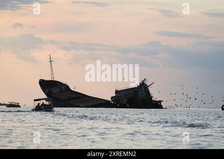 Bateaux touristiques et mouettes entourant l'épave de Sulina au coucher du soleil, mer Noire, Roumanie Banque D'Images