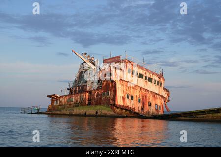 Rusty Shipwreck MV Turgut Usta reflétant dans l'eau au coucher du soleil, mer Noire, Roumanie Banque D'Images