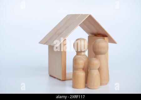 Figure de famille avec fond de maison en bois. Concept d'assurance. Banque D'Images