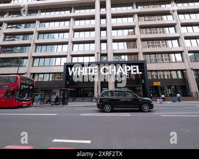 Le White Chapel Building, un parc d'affaires moderne à Whitechapel, Londres, avec un taxi noir de passage au premier plan, Royaume-Uni Banque D'Images