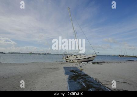 Voiliers de plage après une tempête à Gulfport Beach Floride. Des bateaux et des yachts ont débarqué de la baie de Boca Ciega après de forts vents. Soleil tôt le matin Banque D'Images