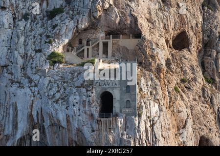 Vue de face de la façade au milieu de la falaise de Porto Flavia, une galerie de zinc a mine conçue par l'ingénieur Cesare Vecelli en 1924, Masua, en Sardaigne Banque D'Images