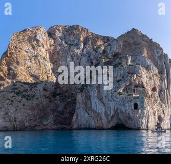 Falaise sur la mer Méditerranée à Masua, sur l'île de Sardaigne en Italie avec la porte du port de Porto Flavia au milieu de la falaise un zinc un ancien abandon Banque D'Images