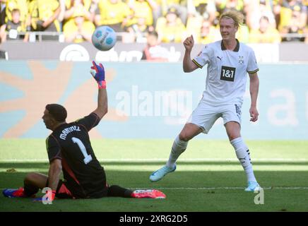 Dortmund, Allemagne. 10 août 2024. Football : test matches, Borussia Dortmund - Aston Villa. Julian Brandt de Dortmund marque son but pour faire 2-0 contre le gardien d'Aston Villa Emiliano Martínez. Crédit : Bernd Thissen/dpa/Alamy Live News Banque D'Images