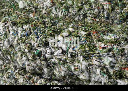 Contexte de tuyau de drainage en plastique enroulé enveloppé de fibre d'herbe artificielle, produit à partir de déchets résiduels de champs d'herbe artificielle usagés Banque D'Images