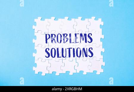 Un puzzle avec le mot problèmes écrit dessus. Les pièces du puzzle sont dispersées et le mot solutions est écrit en bleu Banque D'Images