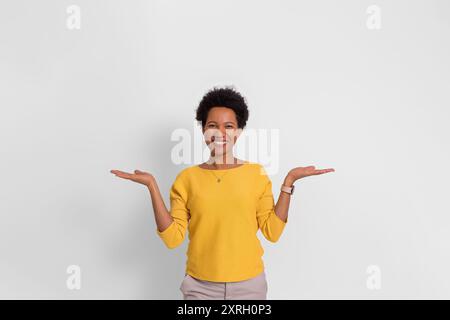 Portrait du directeur des ventes souriant démontrer l'espace vide et comparer les produits sur fond blanc Banque D'Images