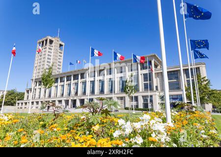 Le Havre 10082024 - Das Rathaus von le Havre wurde nach den Zerstoerungen des Zweiten Weltkriegs von Auguste Perret in moderner Architektur mit einem 72,2 Meter hohen Rathausturm entworfen und 1958 eingeweiht. DAS Gebaeude ist 143 Meter lang, aus Stahlbeton und farbigem Beton gefertigt, und der Turm dient als Wahrzeichen der Stadt, das auch vom Meer aus sichtbar ist. IM Inneren des Rathauses befindet sich unter anderem ein Ratssaal, dessen Suedwand von einem Wandteppich von Jean Lurcat aus dem Jahr 1958 geschmueckt wird.. Le Havre ist eine Stadt im Nordwesten Frankreichs am Ärmelkanal im DÃ p Banque D'Images
