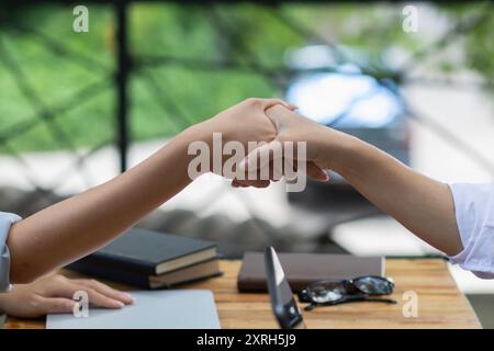 La jeune femme d’affaires a serré la main à des conseillers juridiques après avoir rédigé un contrat à signer par les investisseurs et à assurer la légitimité. Idée commerciale avec Banque D'Images