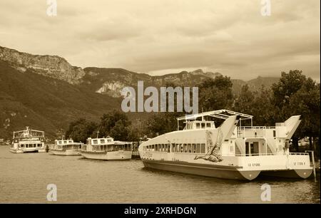 Lac d'Annecy, France - 24 août 2015 : amarrage d'un bateau restaurant de croisière au lac d'Annecy. Annecy Lake Boat Company propose des croisières guidées. Photo sépia Banque D'Images