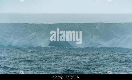 A23a Iceberg Antarctica Ice Cave Close Up Rough Seas Moody Clouds Fog et Dark Ocean. Vue panoramique sur les changements climatiques de la plate-forme de glace Banque D'Images