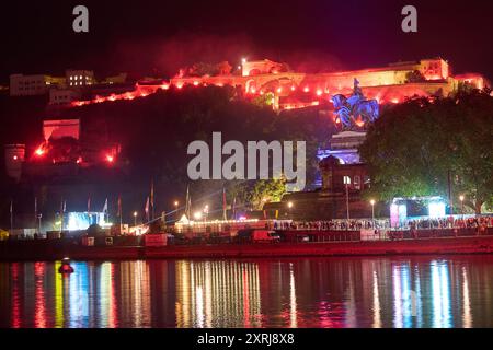 Coblence, Allemagne. 10 août 2024. La forteresse d'Ehrenbreitstein est illuminée par des lumières du Bengale avant que le feu d'artifice final du Rhin in in Flames ne commence. Le spectacle de feux d'artifice « Rhin in Flames » se déroule chaque année le long des plus beaux tronçons du Rhin de mai à septembre. Crédit : Thomas Frey/dpa/Alamy Live News Banque D'Images