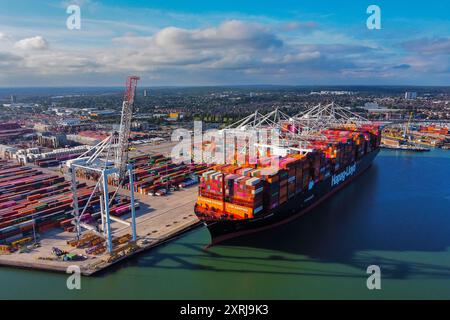 Southampton, Hampshire, Royaume-Uni. 10 août 2024. Vue aérienne générale des Western Docks au port de Southampton dans le Hampshire avec le porte-conteneurs Hapag-Lloyd Damietta Express amarré qui porte le message « Un avenir plus propre pour le transport maritime ». Après le port de Felixstowe, Southampton est le deuxième plus grand terminal à conteneurs au Royaume-Uni, traitant un trafic de 1,5 millions d'équivalents vingt pieds (EVP). Crédit photo : Graham Hunt/Alamy Live News Banque D'Images