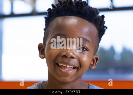 Garçon souriant dans la classe d'école, regardant la caméra, se sentant heureux et confiant Banque D'Images