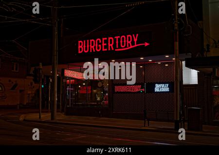 Extérieur du magasin Burgertory à Caulfield, avec une signalisation rouge vif illuminée la nuit, peu de temps après son ouverture Banque D'Images