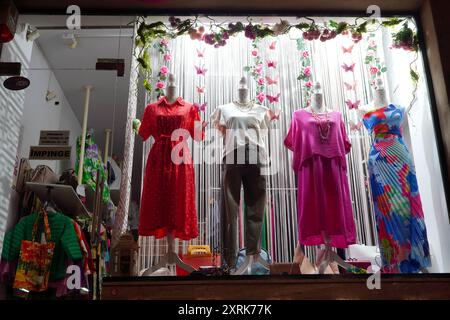 Bucarest, Roumanie - 31 mai 2024 : vêtements de femme de mode exposés sur des mannequins dans la vitrine du boulevard Calea Victoriei la nuit Banque D'Images