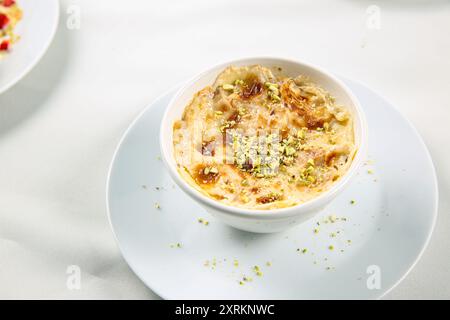 OM Ali. Vue de dessus. Pain égyptien Pudding dans un bol brun isolé sur fond blanc. Vue de dessus. Dessert de pâtisserie sucrée arabe Banque D'Images