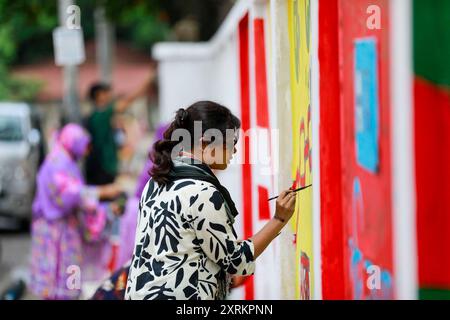 Des élèves peignent un nouveau graffiti sur un mur de rue à Dhaka, au Bangladesh. 10 août 2024. Dans un discours à la nation, le chef d'état-major de l'armée, le général Waker-UZ-Zaman, a annoncé le 5 août 2024 la démission du premier ministre Sheikh Hasina après des semaines de troubles. Photo de Suvra Kanti Das/ABACAPRESS. COM Credit : Abaca Press/Alamy Live News Banque D'Images