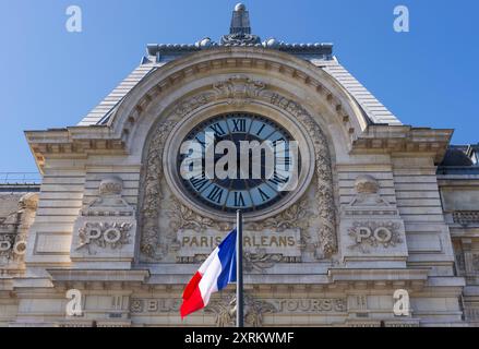 Paris, France 08.08.2024 horloge célèbre du Musée d'Orsay, Musée d'Orsay avec le drapeau français flottant Banque D'Images