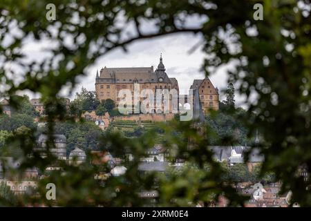 Marburg, Allemagne. 09 août 2024. Le château de Marburg, également connu sous le nom de Landgrave Castle Marburg, s'élève au-dessus de la ville. Vue du sud. Il est né comme un château au XIe siècle et a été converti en palais résidentiel par les Landgraves de Hesse au XIIIe siècle. Depuis 1981, le château abrite le musée d'histoire de l'art de l'Université Philipps de Marbourg. Crédit : Christian Lademann/dpa/Alamy Live News Banque D'Images