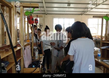 (240811) -- HAIKOU, 11 août 2024 (Xinhua) -- cette photo non datée montre Wu Mingju (C) enseignant la sculpture de coquilles de noix de coco en classe à l'Université normale de Qiongtai à Haikou, dans la province de Hainan, au sud de la Chine. La sculpture de coquille de noix de coco, une forme d'art qui implique la création de dessins à l'aide d'outils de sculpture sur la coquille dure d'une noix de coco, a été répertoriée comme l'un des patrimoines culturels immatériels nationaux en 2008. Wu Mingju, un héritier de la sculpture de coquille de noix de coco, s'est engagé à l'héritage et à la promotion de cet art ancien et complexe depuis 33 ans en explorant l'innovation technique, en créant cocon Banque D'Images