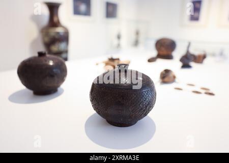 (240811) -- HAIKOU, 11 août 2024 (Xinhua) -- des œuvres de sculpture de coquille de noix de coco réalisées par Wu Mingju sont exposées lors d'une exposition mettant en vedette la ville de Haikou lors de la Conférence annuelle 2024 du Forum de Boao pour l'Asie qui s'est tenue à Boao, dans la province de Hainan, dans le sud de la Chine, le 26 mars 2024. La sculpture de coquille de noix de coco, une forme d'art qui implique la création de dessins à l'aide d'outils de sculpture sur la coquille dure d'une noix de coco, a été répertoriée comme l'un des patrimoines culturels immatériels nationaux en 2008. Wu Mingju, un héritier de la sculpture de coquille de noix de coco, a été engagé dans l'héritage et la promotion de cet ancien et complexe Banque D'Images