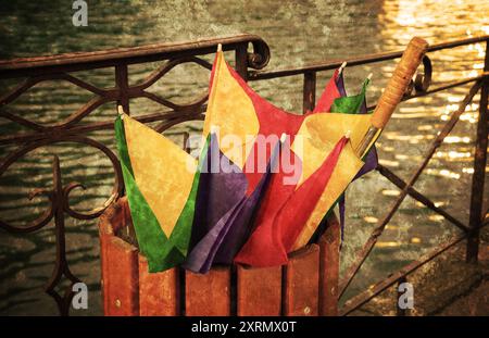 Lac d'Annecy après la pluie. Parapluie coloré cassé dans la poubelle. Photo grungy rétro vieillie avec des rayures. Banque D'Images