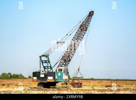 Grue télescopique sur chenilles travaillant pour nettoyer le canal Banque D'Images